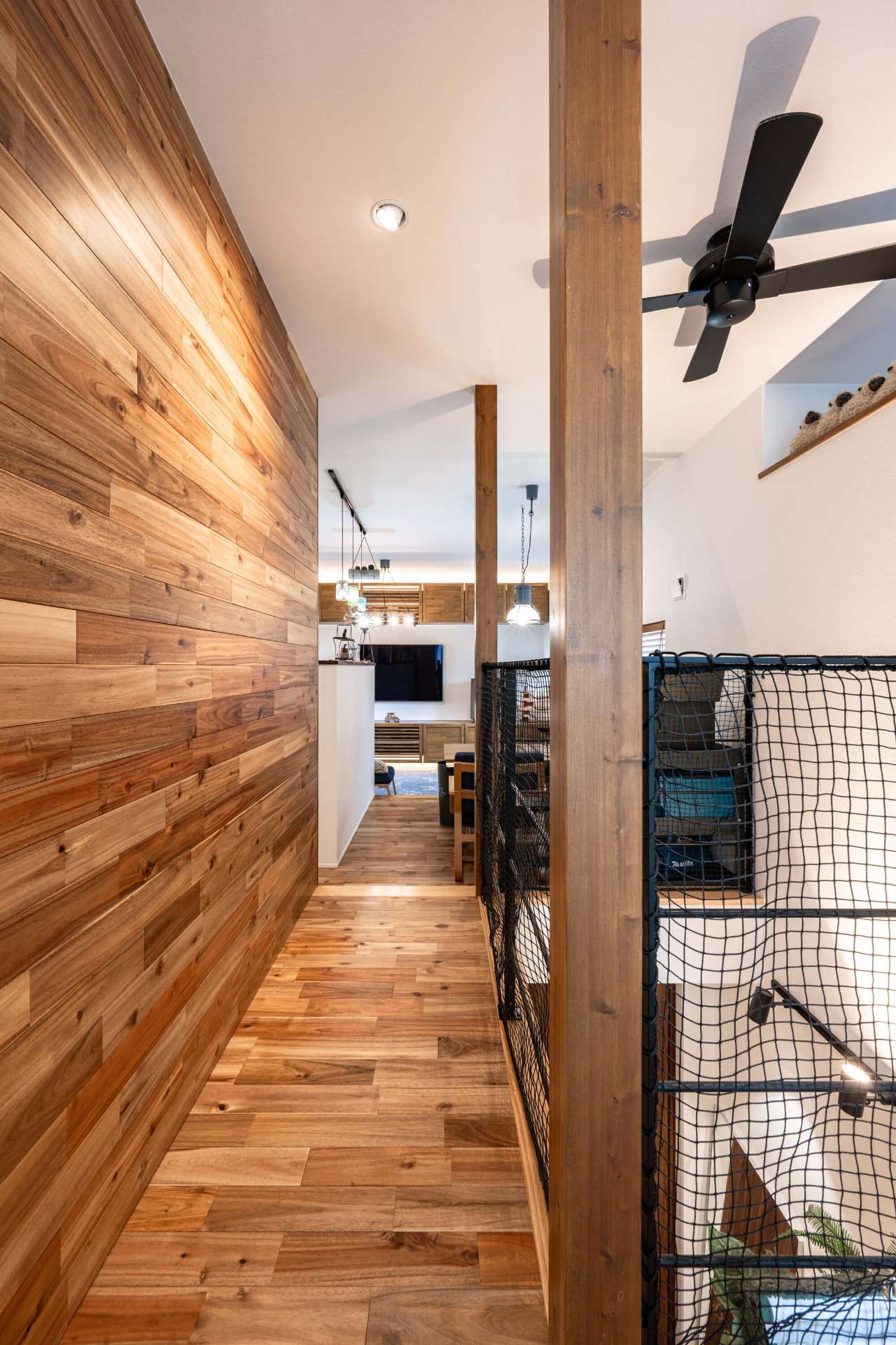 吹抜けに設けた照明とシーリングファンがインテリアのアクセント