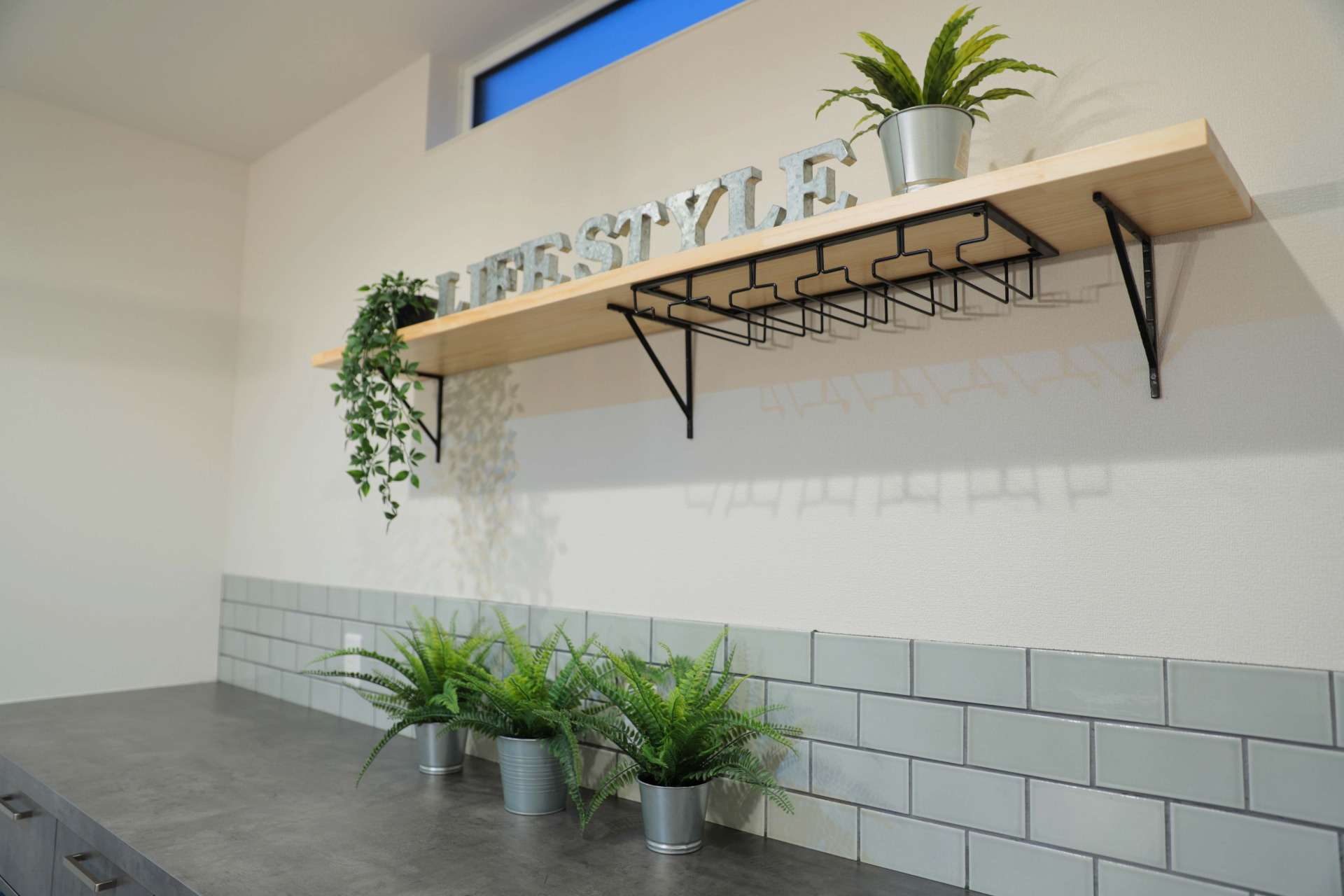 飾り棚や光を取り込む高窓のあるキッチン