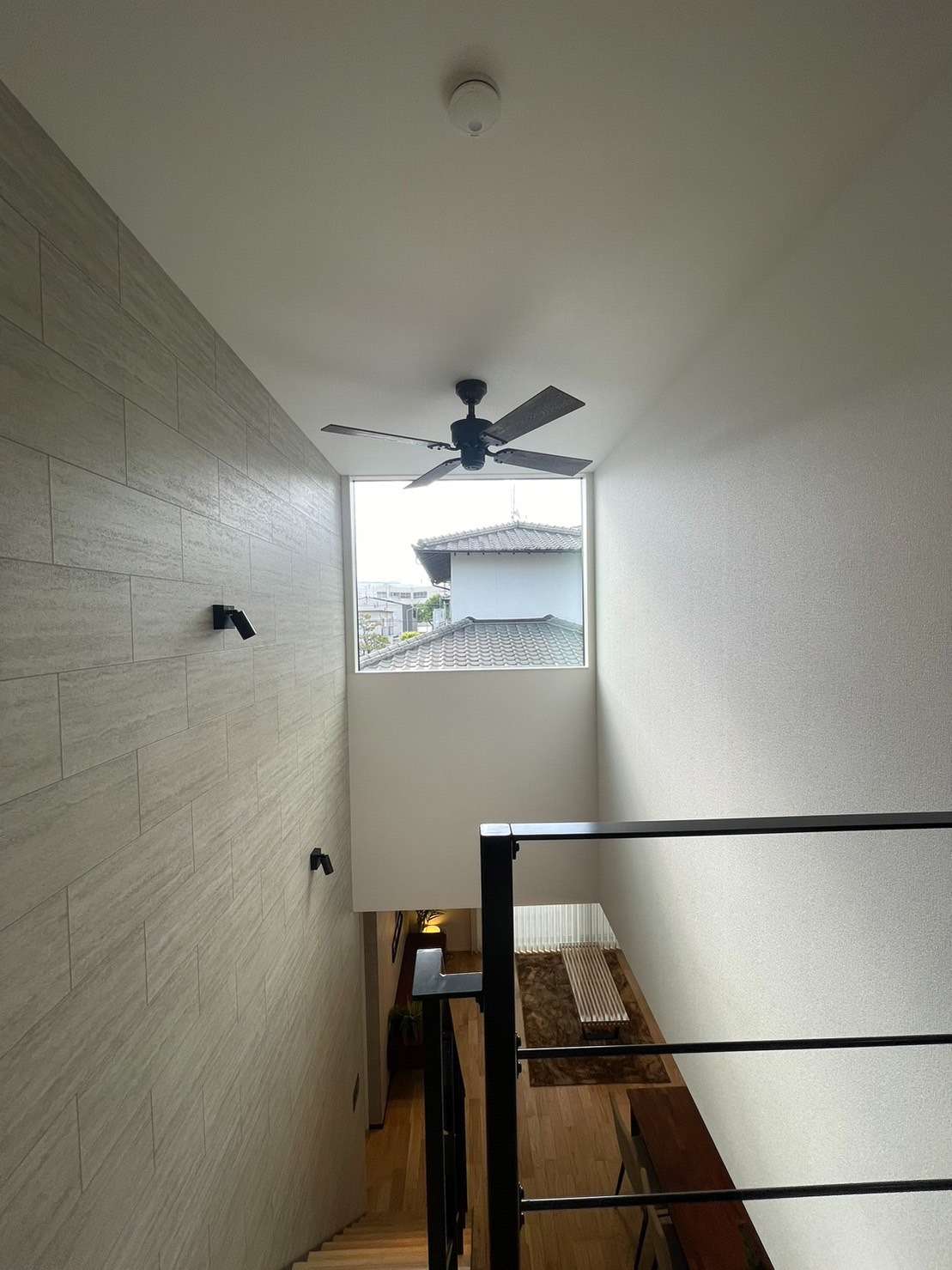 ピクチャーウインドウから光が差し込む吹抜け階段