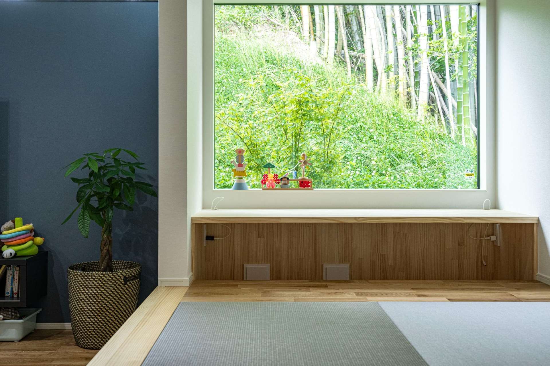 小上がりの和室に設けられた、中庭（借景）を望む造作カウンター。古賀市の穏やかな自然を切り取り、料理の合間の休憩や子どものスタディコーナーとして機能する、一級建築士ならではの居場所づくり。