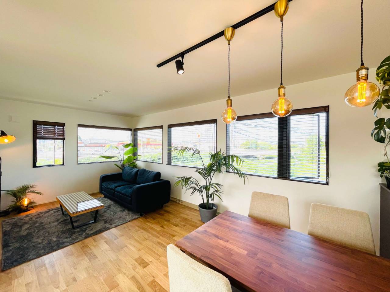 連続する窓から明るい陽光が差し込むリビングダイニング。ZEH基準の断熱性能により、窓が多くても外気温の影響を受けにくい、宗像市の気候に最適化されたパッシブデザインの住まい。