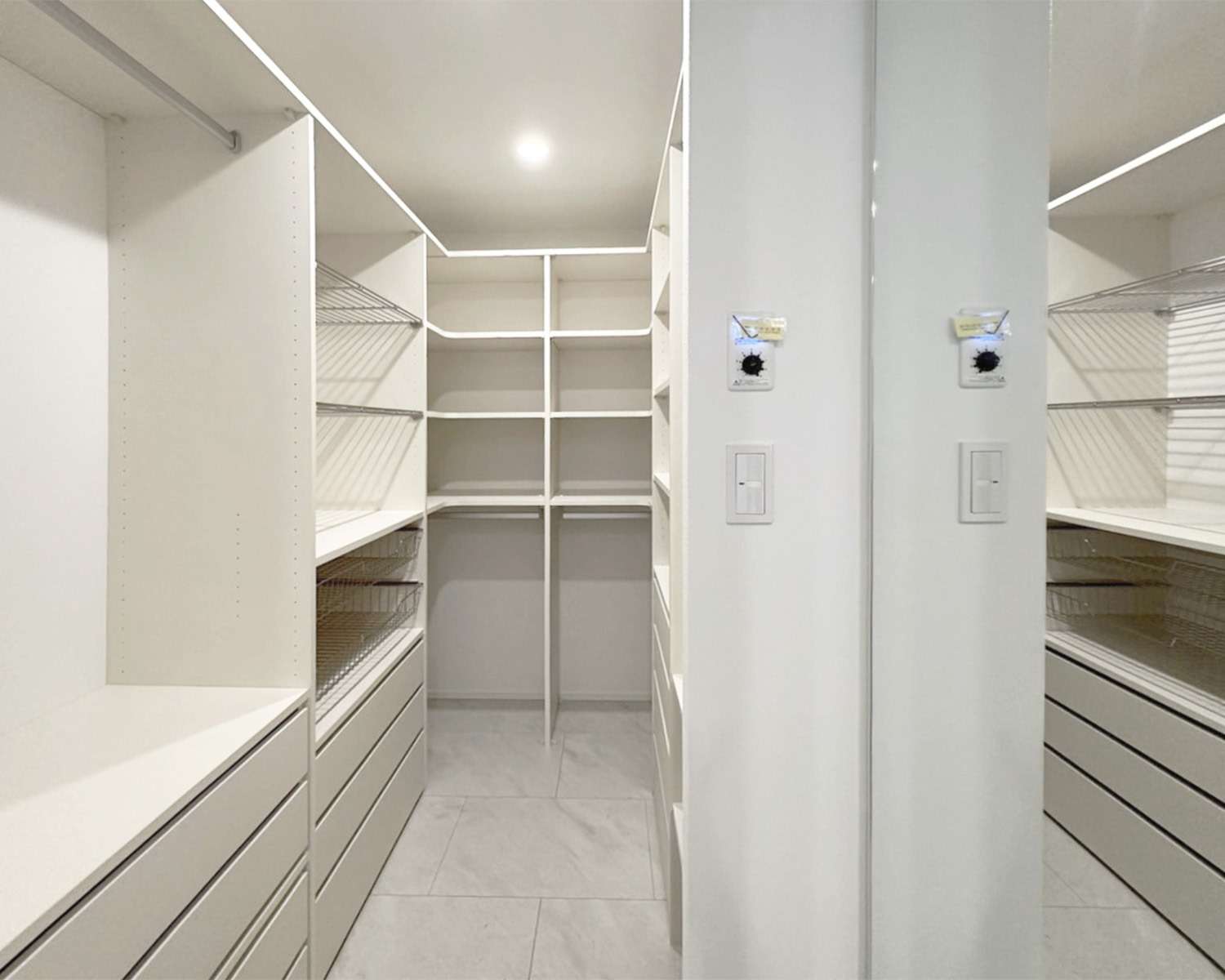 福岡市東区の注文住宅：白を基調とした清潔感のある大容量ウォークインクローゼット。ハンガーパイプと引き出しを組み合わせたシステム収納