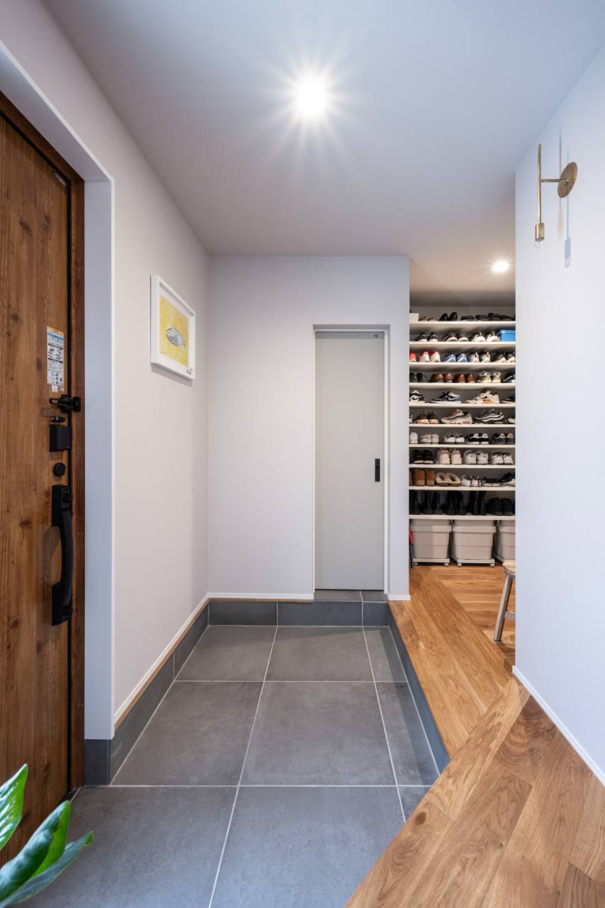 宗像市の新築平屋の玄関ホール。土間から直接アクセスできる大容量のシューズクロークを備え、家族の靴を効率よく収納。家事動線をスムーズにする間取り。古賀市の工務店・ライフスタイル設計。