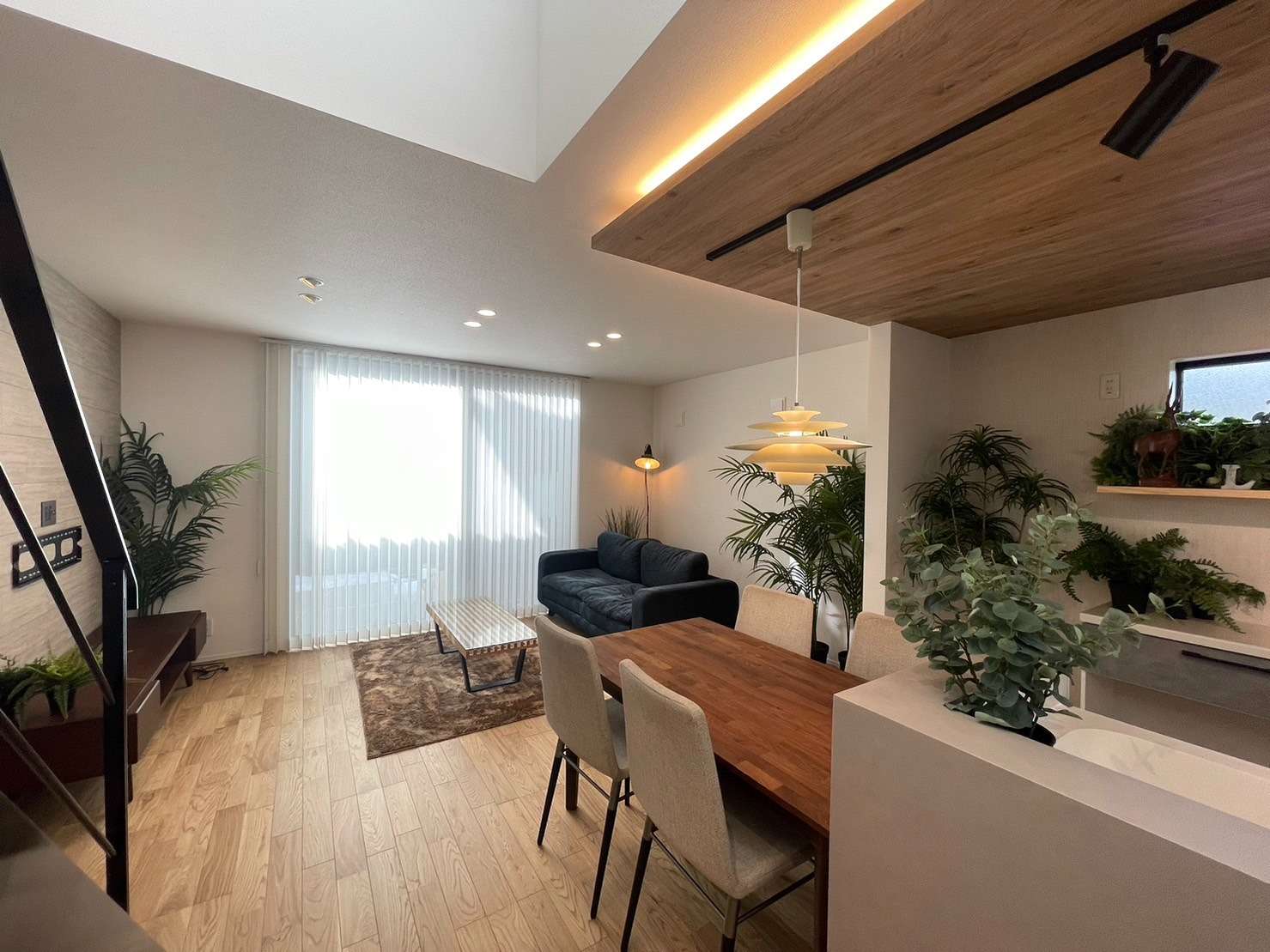 福岡県古賀市に建つ新築注文住宅の内観、キッチンとダイニングから続く、大きな窓のある明るいリビング