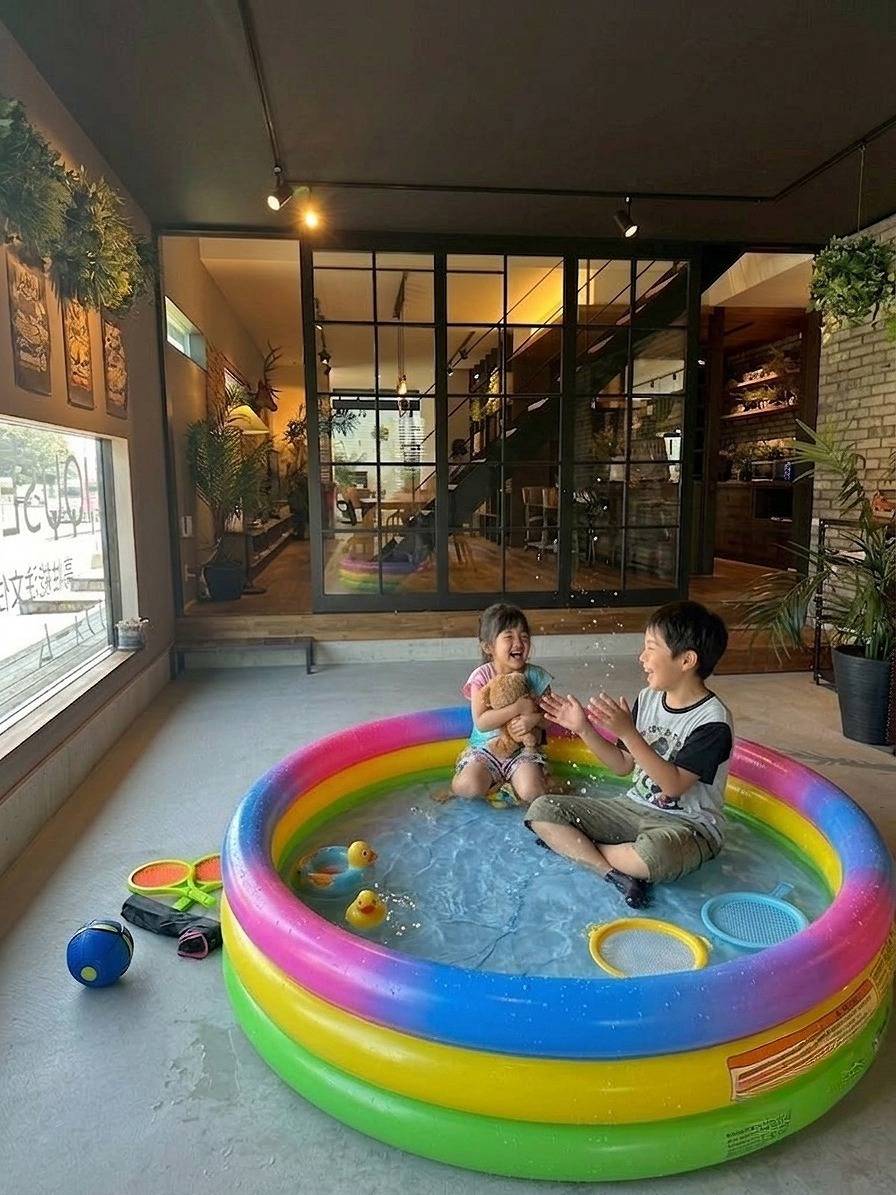 ガレージ内で子どもたちがビニールプールで水遊びする様子遊んだり