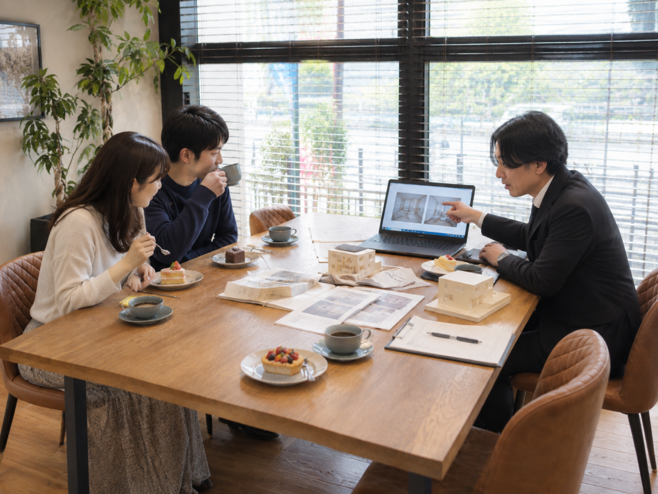 建築士とご夫婦がパースを見ながら楽しそうに打ち合わせをしている様子